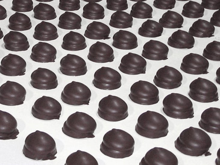 Kẹo phủ chocolate nằm trên dây đai Chiorino màu trắng